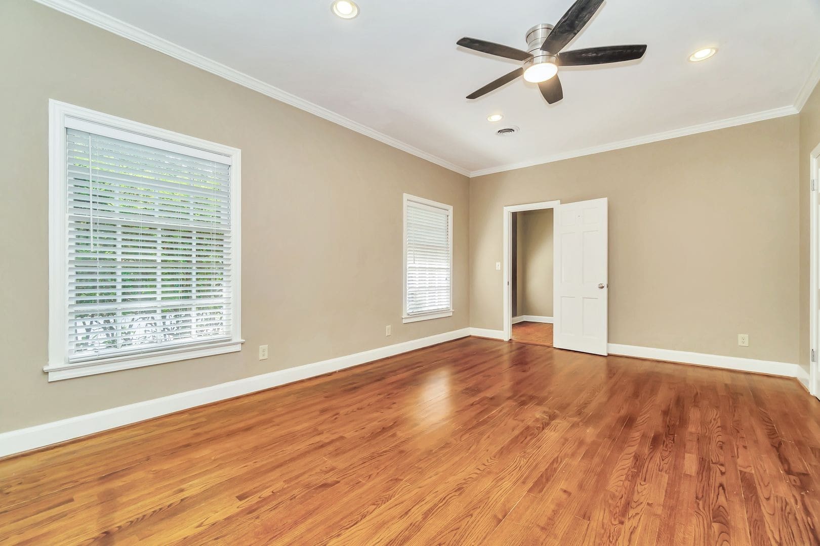 Empty bedroom with hardwood floors and ceiling fan